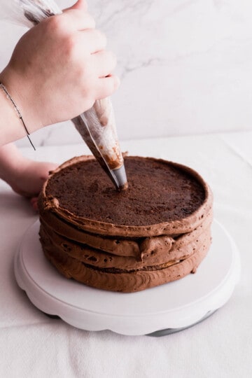 add-frosting-to-moist-triple-chocolate-ganache-cake.
