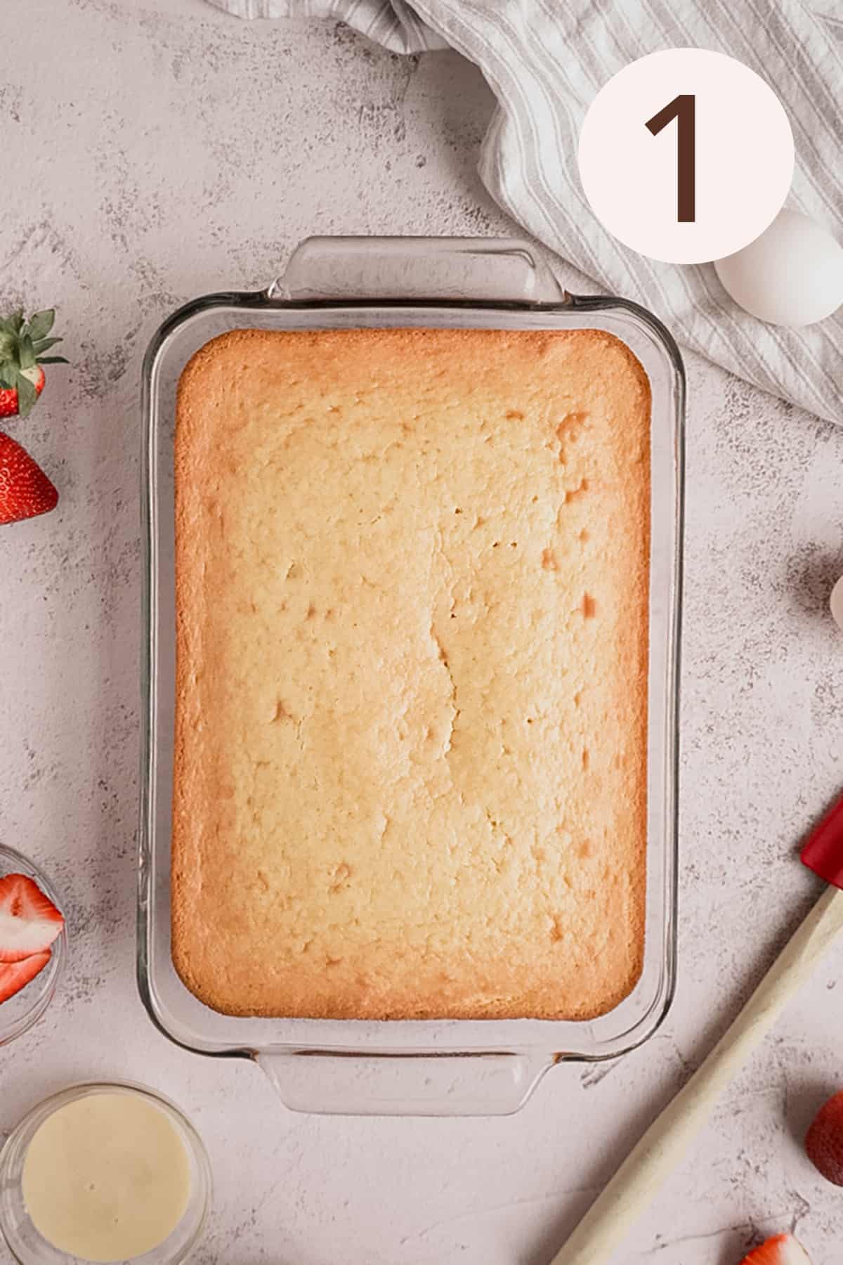 Yellow cake in a glass cake pan on a white backgound.