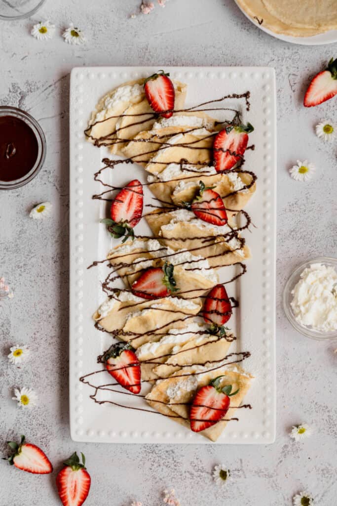 sweet-crepes-with-strawberries-and-cream-on-platter.